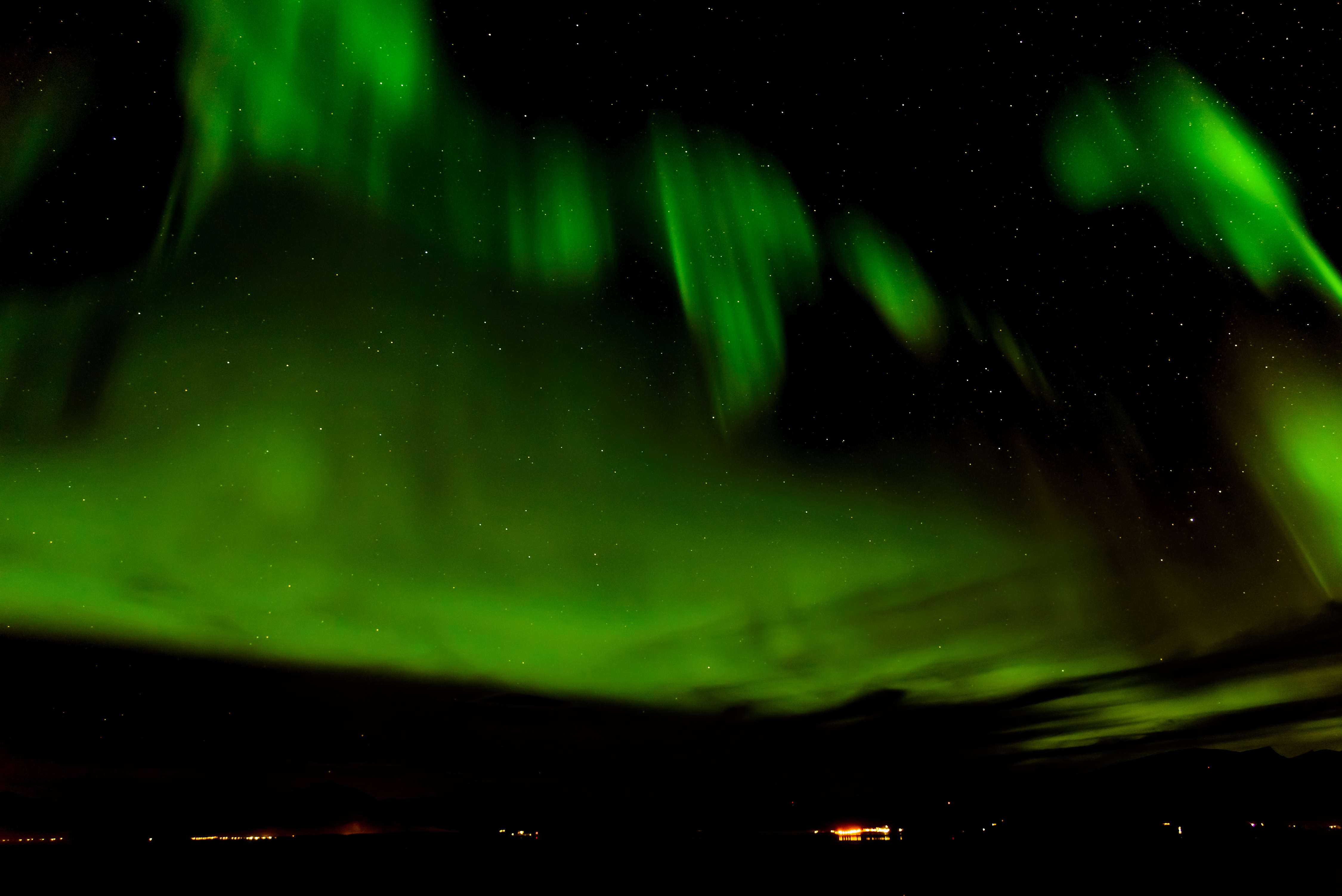แสงเหนือ Aurora Borealis เหนือภูเขาและบ้านไม้ในเมืองทรอมโซ ประเทศนอร์เวย์